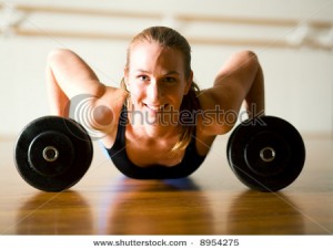 stock-photo-powerful-lady-doing-push-ups-on-dumbbells-8954275